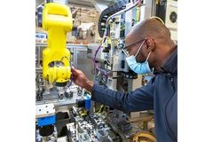 Engineer working with robotic arm in industrial automation setting